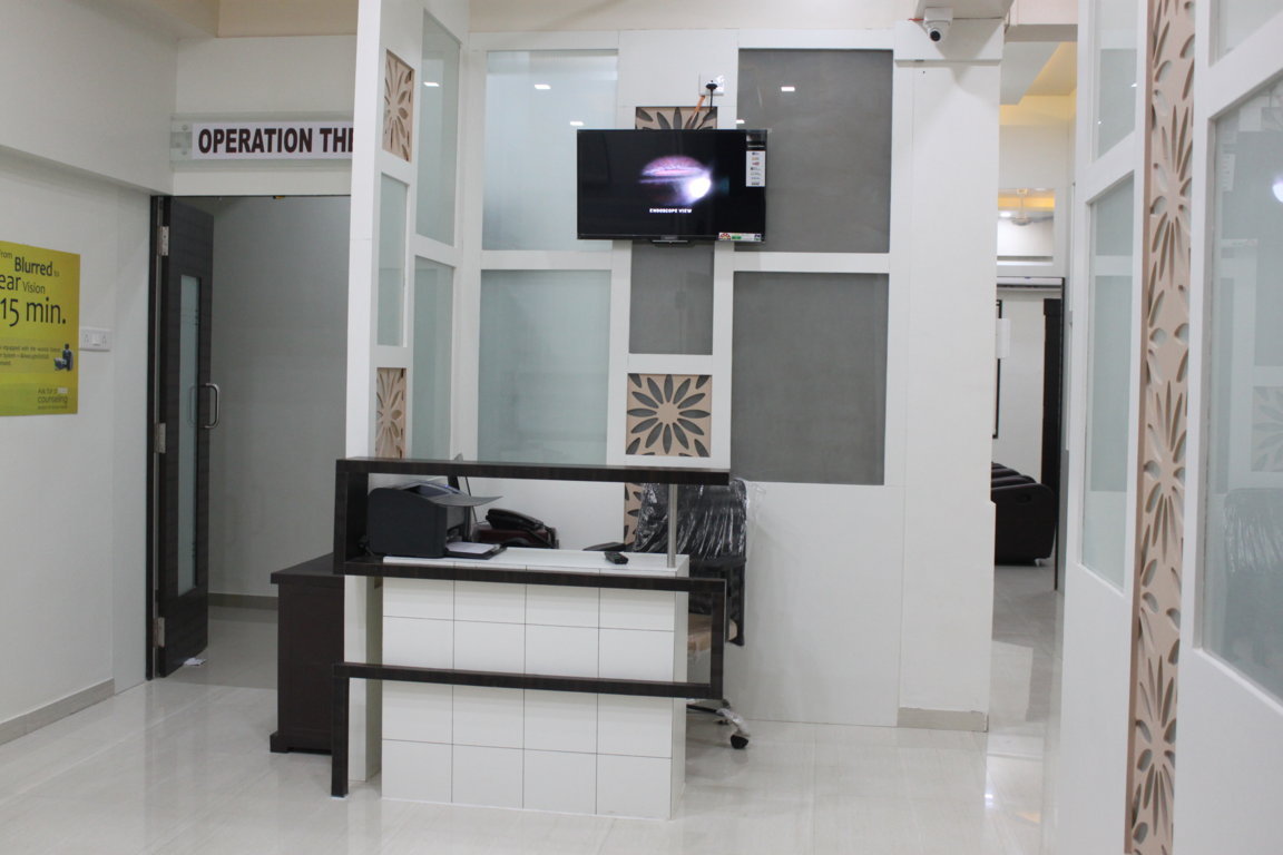 Operation theatre concierge counter at Insight Institute with a printer-equipped check-in desk and a live endoscope-view feed on the back wall